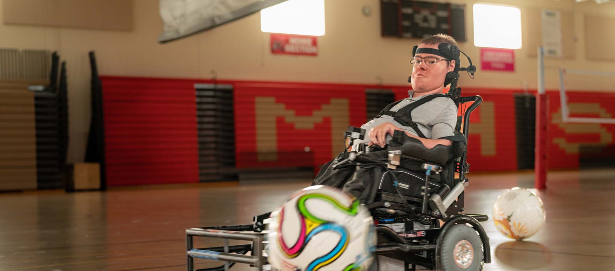 Nathan dans un gymnase jouant avec un ballon de football